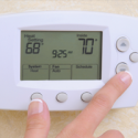 a-person-adjusting-thermostat-temperature