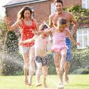 family-playing-in-sprinkler